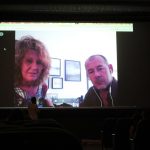 Immagine su un grande schermo di un uomo e una donna che vengono intervistati